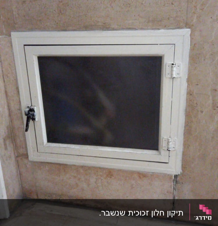 חלון זכוכית עם מסגרת לבנה וקיר אבן